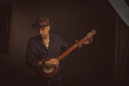 a white person with a hat holding a banjo